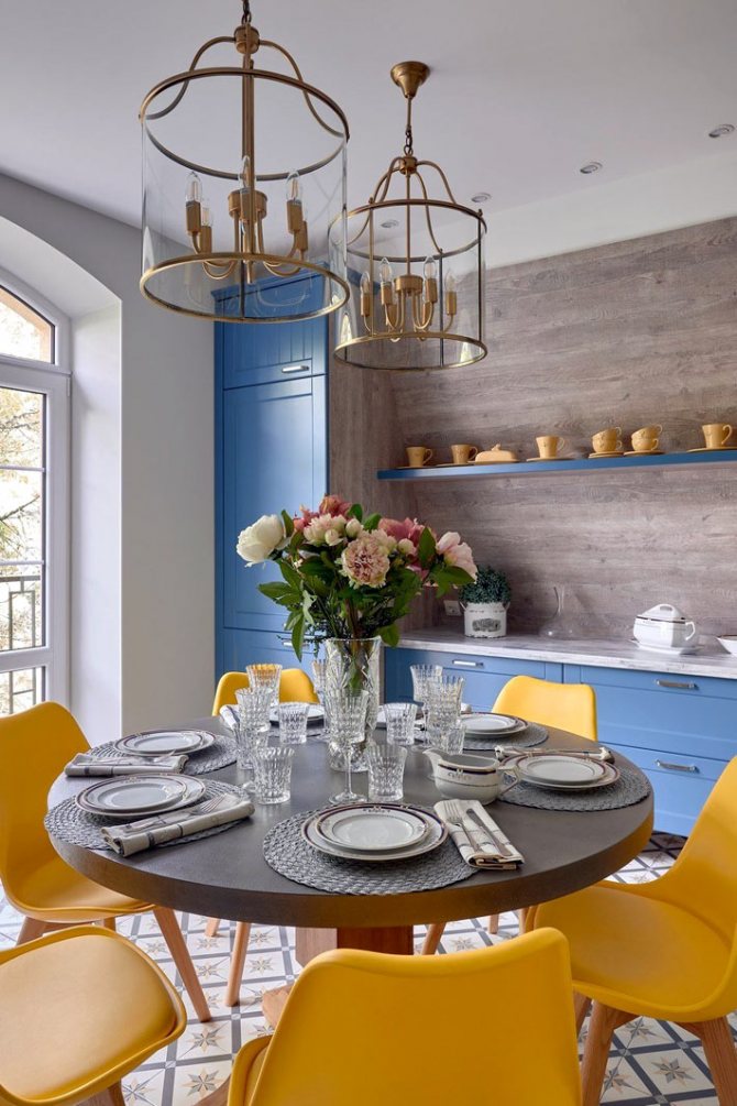 яскраво-жовті пластикові стільці на кухні з синіми меблями